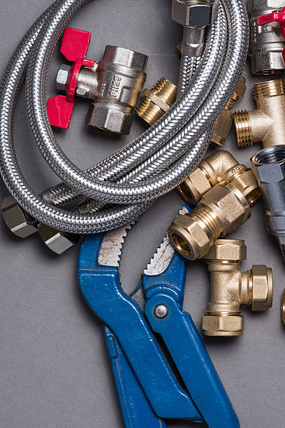 istock Adjustable spanner with assorted plumbing fittings and hose on grey 546787978