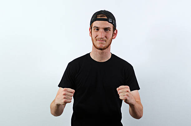 Happy Young Adult Male in Dark T-Shirt Happy Young Adult Male in Dark T-Shirt and Baseball Hat Worn Backwards back to front stock pictures, royalty-free photos & images