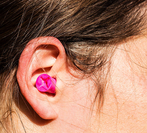 Plugged womans ear Plugged womans ear for protection. stopper stock pictures, royalty-free photos & images