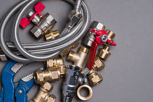 istock Adjustable spanner with assorted plumbing fittings and hose on grey 546788336
