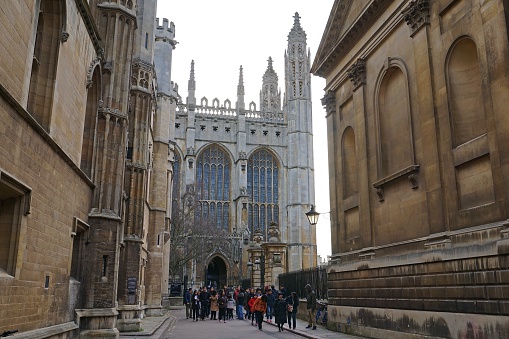Cambridge, UK - December 20, 2015: A group of Asian tourists exits King's College Chapel during a sightseeing tour of Cambridge, England.