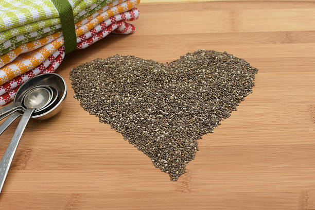 測定スプーンで心臓の形をしたチアシード - tablespoon chia healthy eating seed ストックフォトと画像