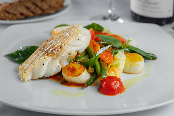 istock baked fish with asparagus and onion on a white plate 546790814