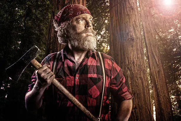 A portrait of a woodsman with an axe in the forest