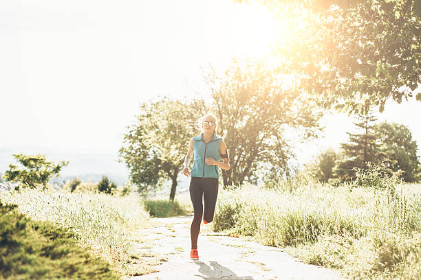 istock Young female athlete running on sunny trail in park 546794450