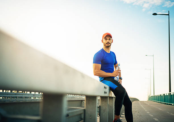 istock Exhausted recreational athlete drinking water after jogging 546794934