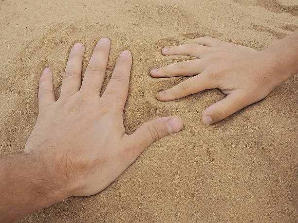 istock Father and son hands on sand. Close up 546795904