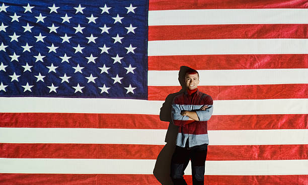 istock Smiling man standing in front of American flag 546795928