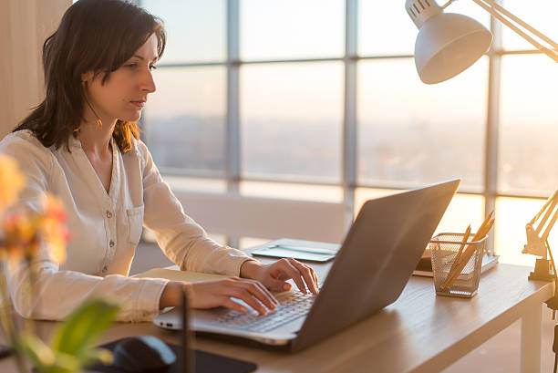 istock Side view photo of a female programmer using laptop, working 546797122
