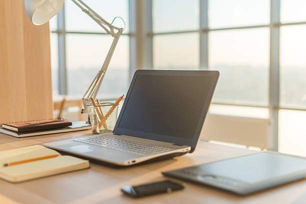 istock Side view picture of studio workplace with blank notebook, laptop 546799446
