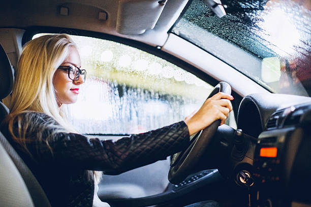 businesswoman driving a car at night - driving car drive women imagens e fotografias de stock