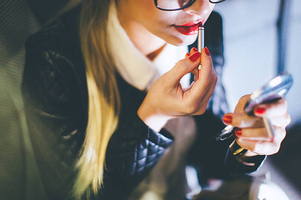 istock Blonde woman applying lipstick looking at mirror 546801802
