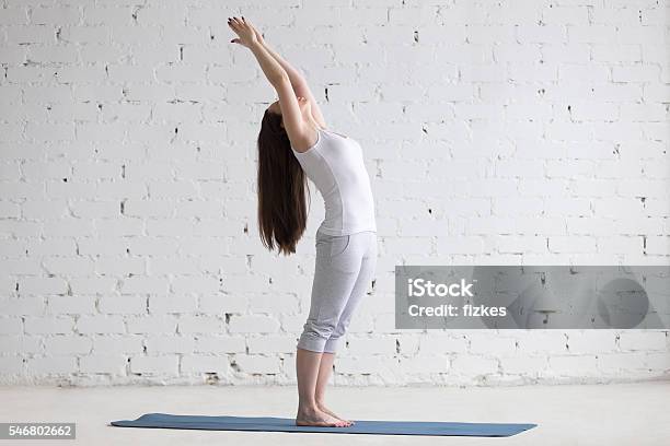 Beautiful Sporty Young Woman Doing Standing Backbend Pose In Whi Stock Photo - Download Image Now