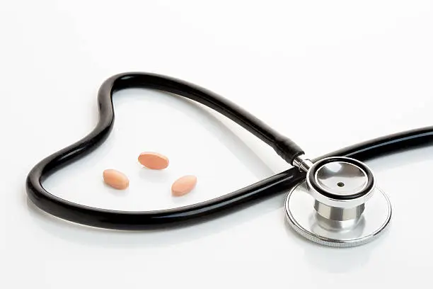 Statin or generic tablets with stethoscope making a heart shape.