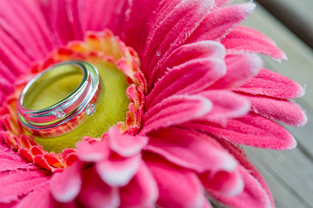 istock Wedding rings on a flower on a wooden table. 546807754