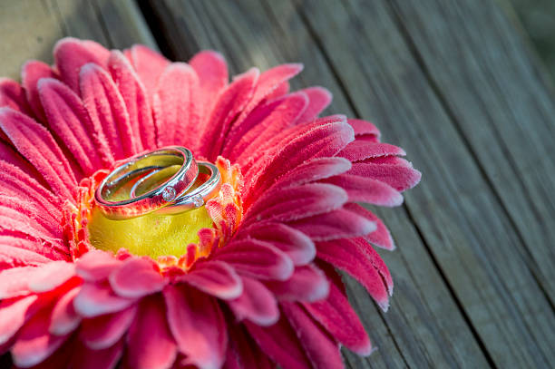 istock Wedding rings on a flower on a wooden table. 546807790