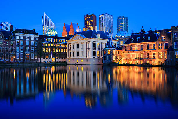 Skyline of The Hague at dusk during blue hour The Hague, Netherlands - February 16, 2016: Skyline of The Hague with the modern office buildings behind the historic Mauritshuis museum and the Binnenhof parliament building next to Hofvijver lake in the Netherlands at dusk during the blue hour. binnenhof photos stock pictures, royalty-free photos & images