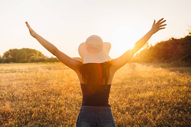 istock Young woman outstretched arms enjoys sunset 547009240