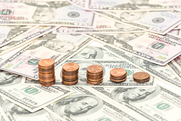 istock Columns of the cents coins on the dollars banknotes 547010426