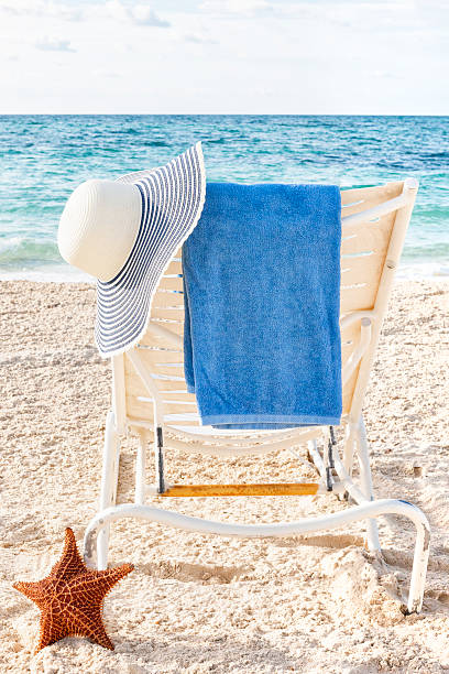 istock Lounge chair with hat, towel and starfish on beach 547010986