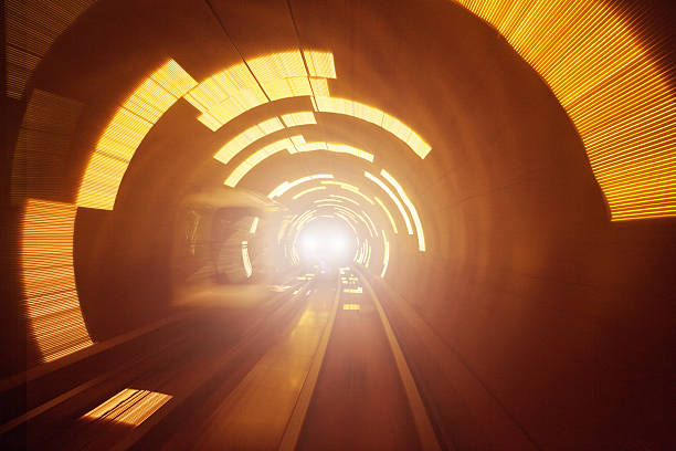 Train in the Futuristic Tunnel Abstract blurred light waves in a tunnel light at the end of the tunnel stock pictures, royalty-free photos & images