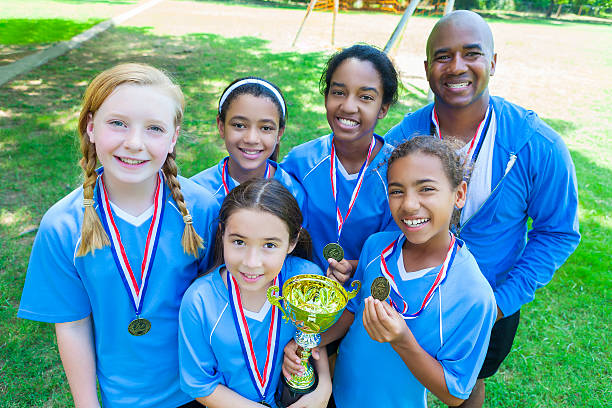 istock Winning girls soccer team with coach 547011312