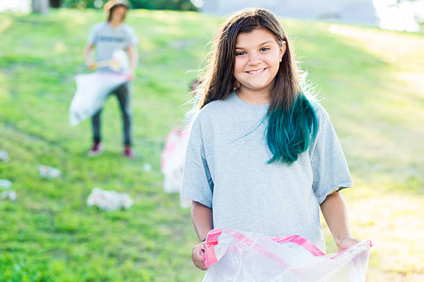 istock Pretty girl picking up trash at local park 547011456