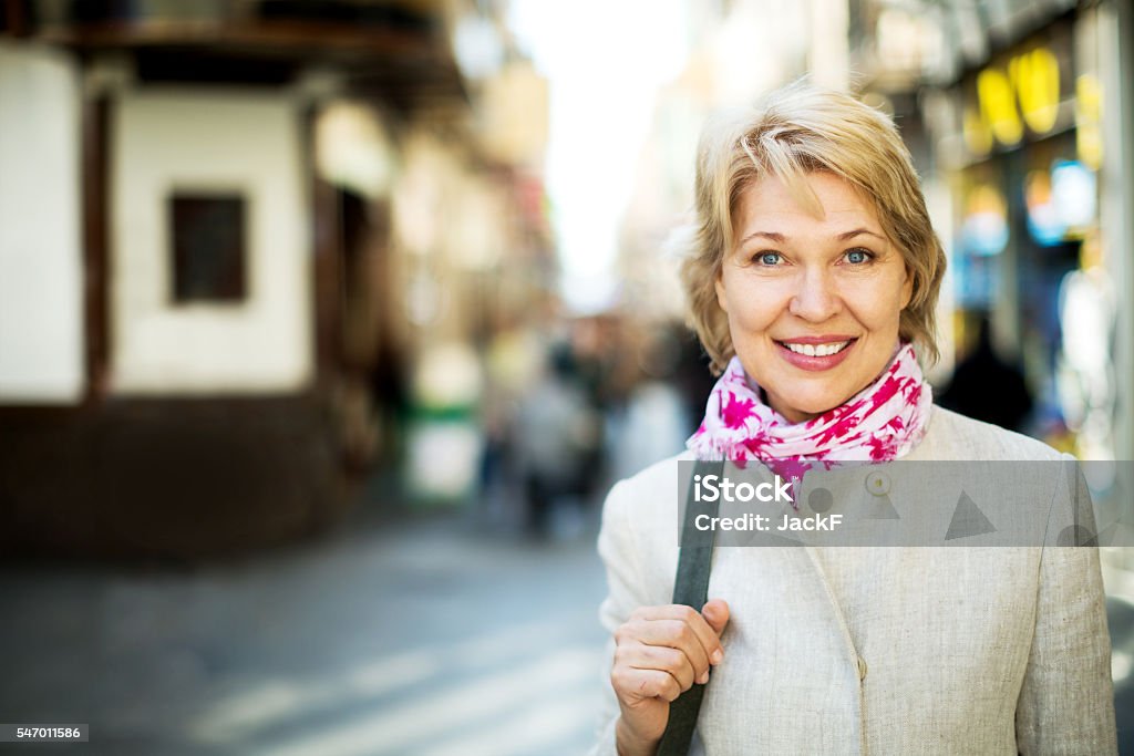 Cheerful retiree woman having a walk in city Closeup of positive retiree woman having a walk in city Women Stock Photo