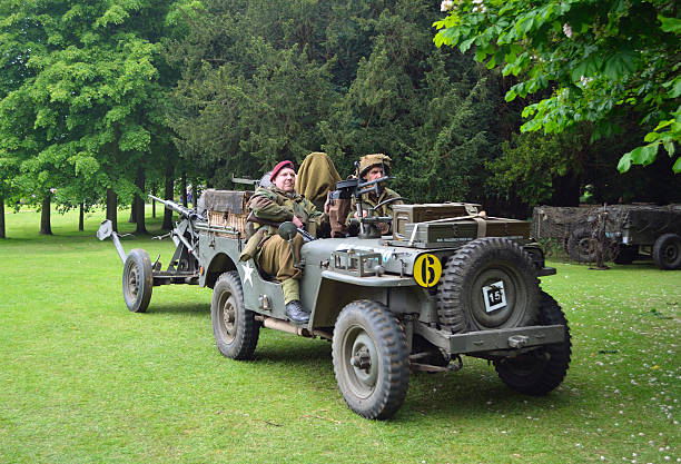World War 2 Jeep Silsoe, Bedfordshire, England - May 30, 2016: World War 2 Jeep with men dressed as World War 2 Soldiers, towing Gun. jeep 4x4 off road vehicle world war ii stock pictures, royalty-free photos & images