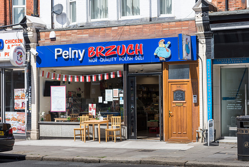 London, England - July 6, 2016:  Front view of a Polish Grocery Store/Delicatessen with table and chairs outside.