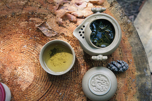 Tea set of Yixing clay. In the shade of the trees on a large stump.