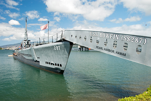 Pearl Harbor, USA - April 1st, 2022: USS Arizona Memorial with Admiral Clarey Bridge in the background. National historic sites at Pearl Harbor tell the story of the battle that plunged US into World War II.