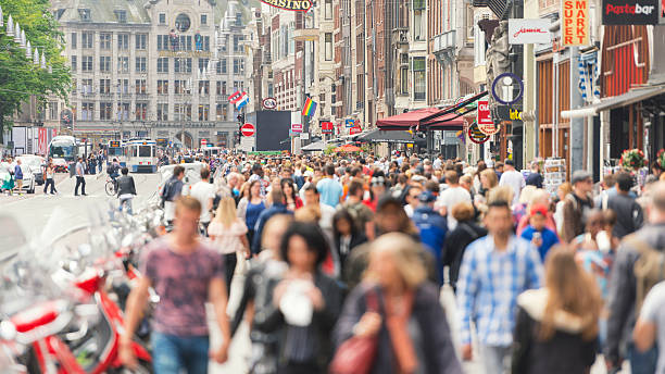 estrada damrak de amsterdã - crowd store europe city street - fotografias e filmes do acervo