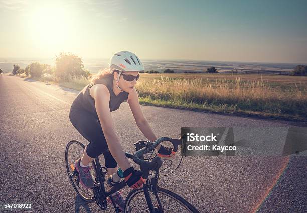 Pretty Young Fit Frau Reitrad Bei Sonnenuntergang Stockfoto und mehr Bilder von Radfahren - Radfahren, Frauen, Rennrad