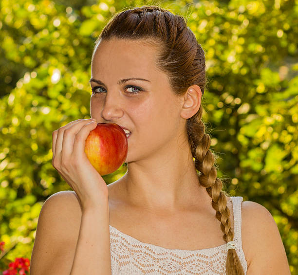 istock Beautiful Healthy Woman eating red apple. 547018944