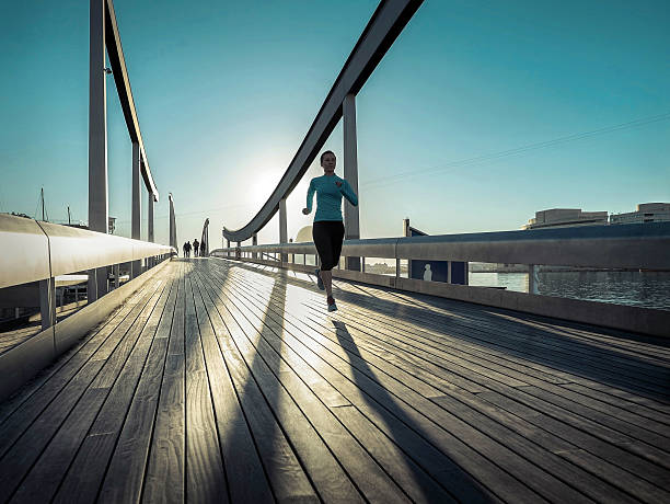 istock Woman running on the bridge under sunlight. 547020612