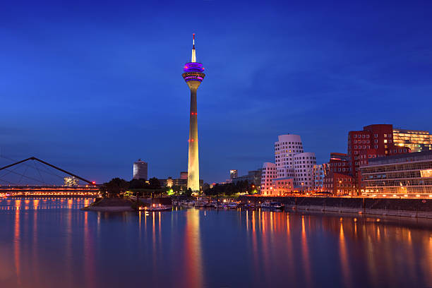 Dusseldorf, Germany View of Düsseldorf during the blue hour at the Rhine river with the Rheinturm Tower and the media harbor. düsseldorf stock pictures, royalty-free photos & images