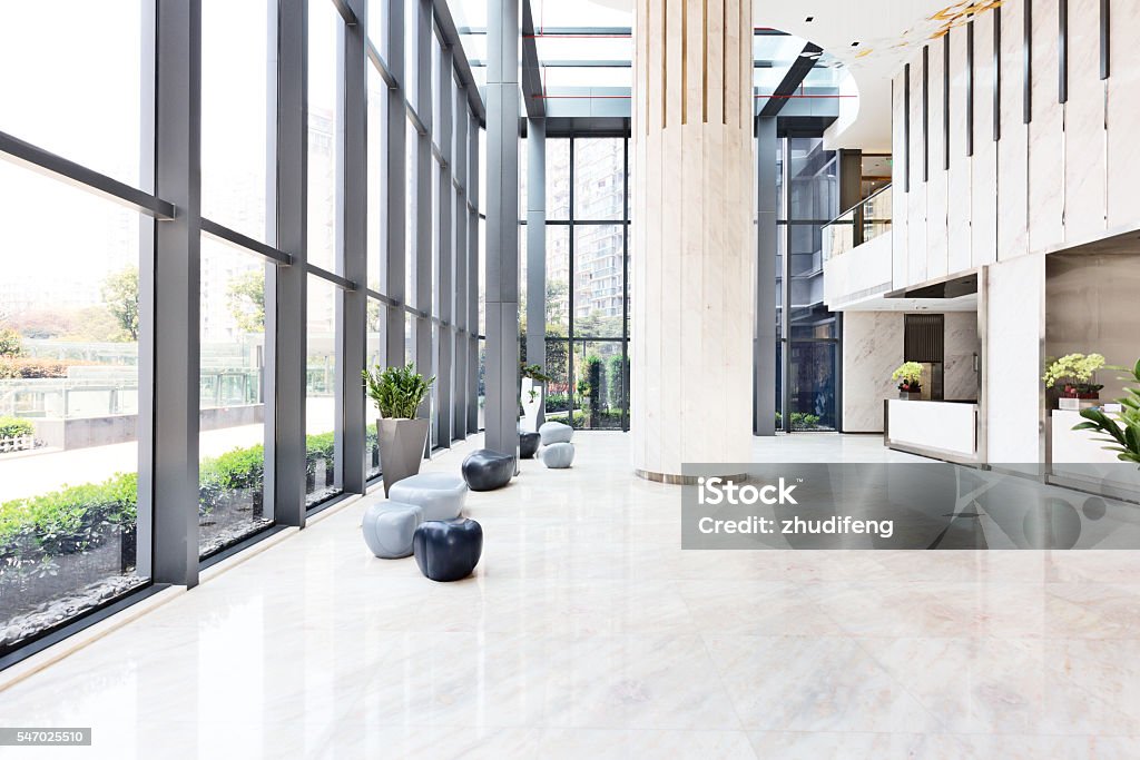 elegantes taburetes y talbe en enorme y luminoso hall - Foto de stock de Sala de espera - Característica de edificio libre de derechos