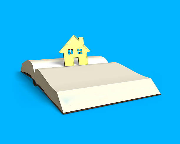 istock golden house standing on opening book isolated in blue 547034530