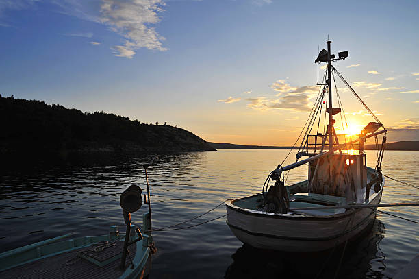 траулер с лодкой на закате у моря - ausfahrt стоковые фото и изображения