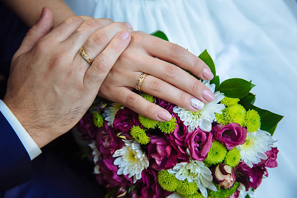 istock marriage hands with rings. on the wedding bouquet background 547041400