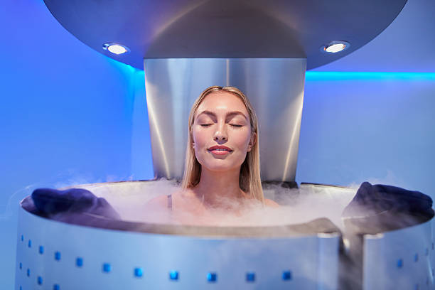 young woman in a whole body cryotherapy cabin - banho terapêutico imagens e fotografias de stock