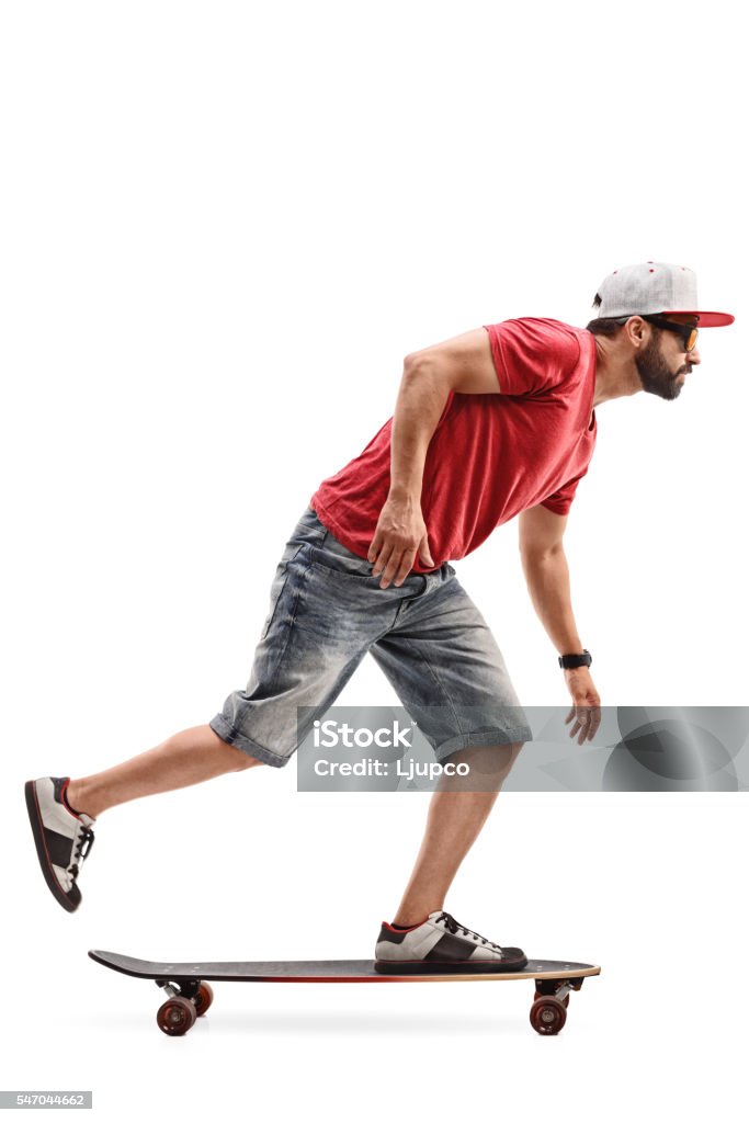 Patinador masculino montando un longboard - Foto de stock de Monopatín - Actividades recreativas libre de derechos