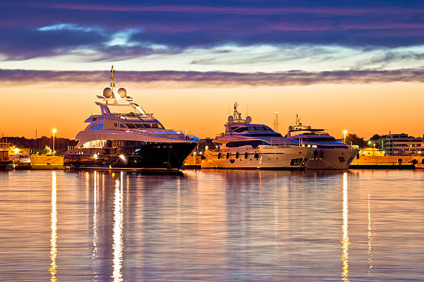 les yachts de luxe se ment à l’heure d’or avec une vue - marina photos et images de collection