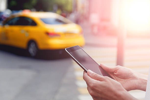 istock Female hands holding tablet on yellow car in background 547047486