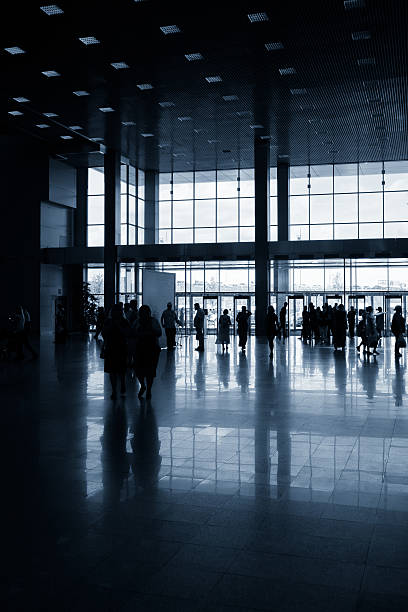 istock Silhouettes of people in modern hall 547047882