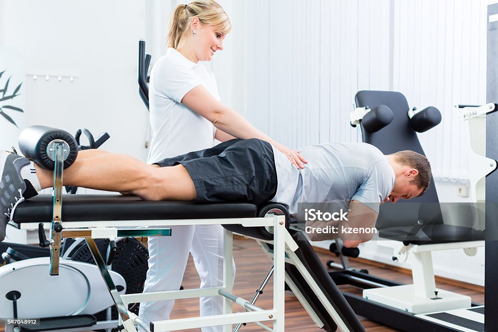 Physiotherapist or sport doctor with patient Patient at the physiotherapy doing physical exercises with therapist with sport doctor Physical Therapist Stock Photo