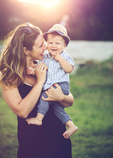 istock Happy mother holding her cheerful son outdoors at sunset 547051760