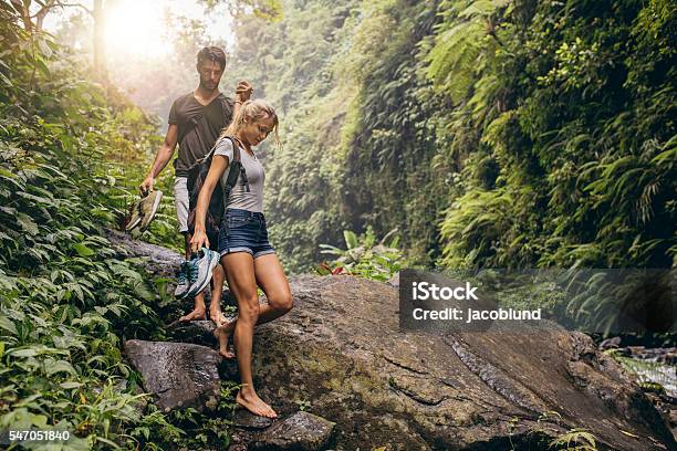 Young Couple Walking Through The Mountain Trail Stock Photo - Download Image Now - Hiking, Rainforest, Walking