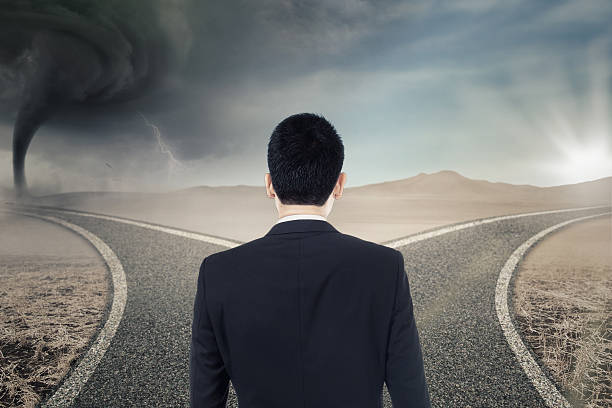 istock Confused businessman looking at two street 547052848